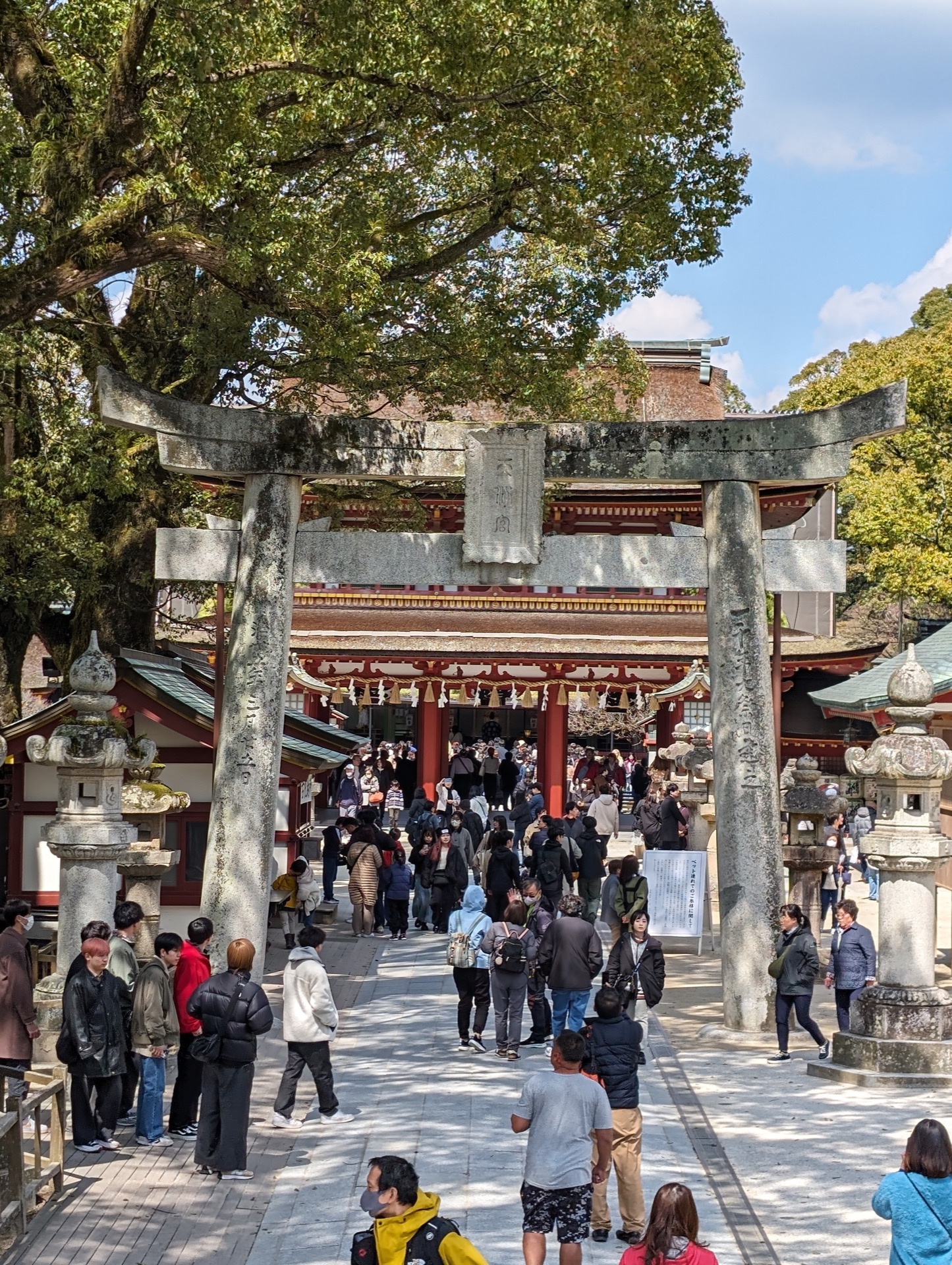 A torii entrance gate with about 30 visitors visible